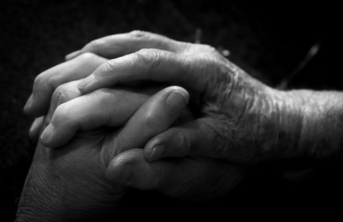 Free Close-up of two hands clasped together in a grayscale setting, evoking connection and care. Stock Photo