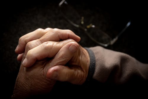 A Close-up Photo of an Elderly People Holding Each Others Hand