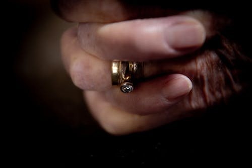 Person Wearing Gold Ring With Diamond