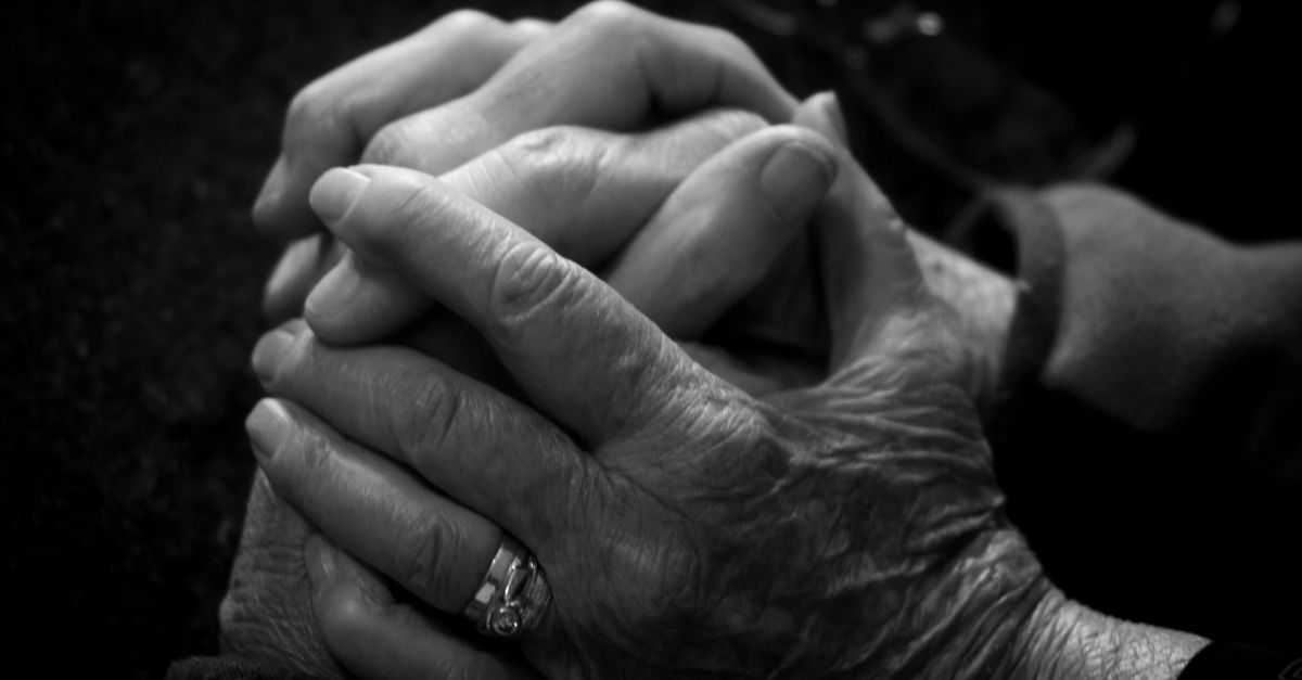 Close-up of intertwined elder and younger hands symbolizing care and connection.