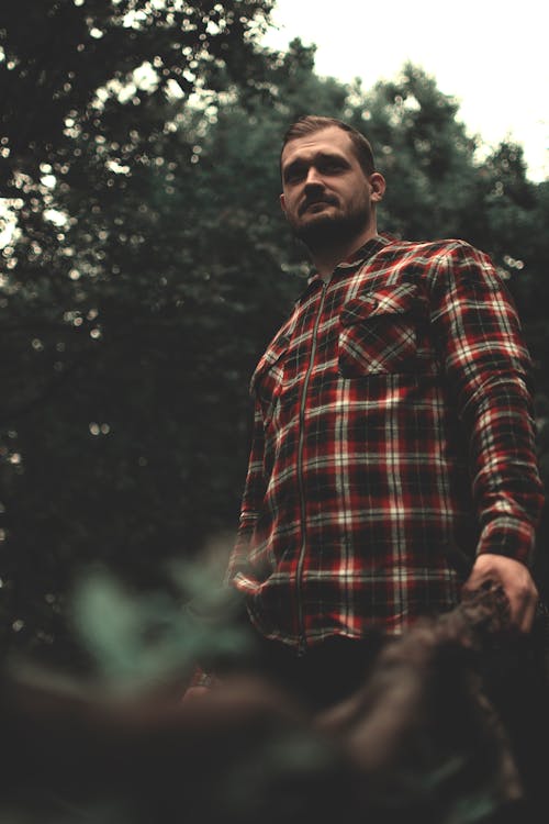 Man in Plaid Long Sleeves Standing Near Green Trees