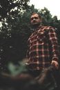 Man in Red and White Plaid Dress Shirt Standing Near Green Trees
