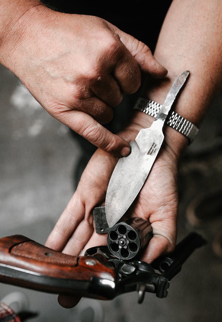 Man Holding A Gun And A Dagger On His Hand