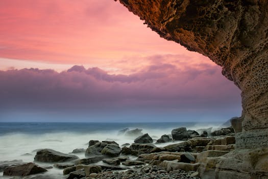 Breathtaking view of a rocky coastline under a vibrant sunset sky, capturing nature's beauty.