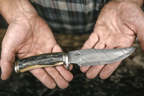 Free Hunting Knife in Hands of Unrecognizable Man Stock Photo