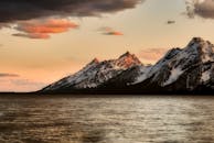 日落时分，雪山壮丽，湖水宁静，构成了一幅令人惊叹的自然画卷