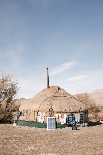 A modern solar-powered glamping tent with string lights and a sunrise view over a quiet landscape
