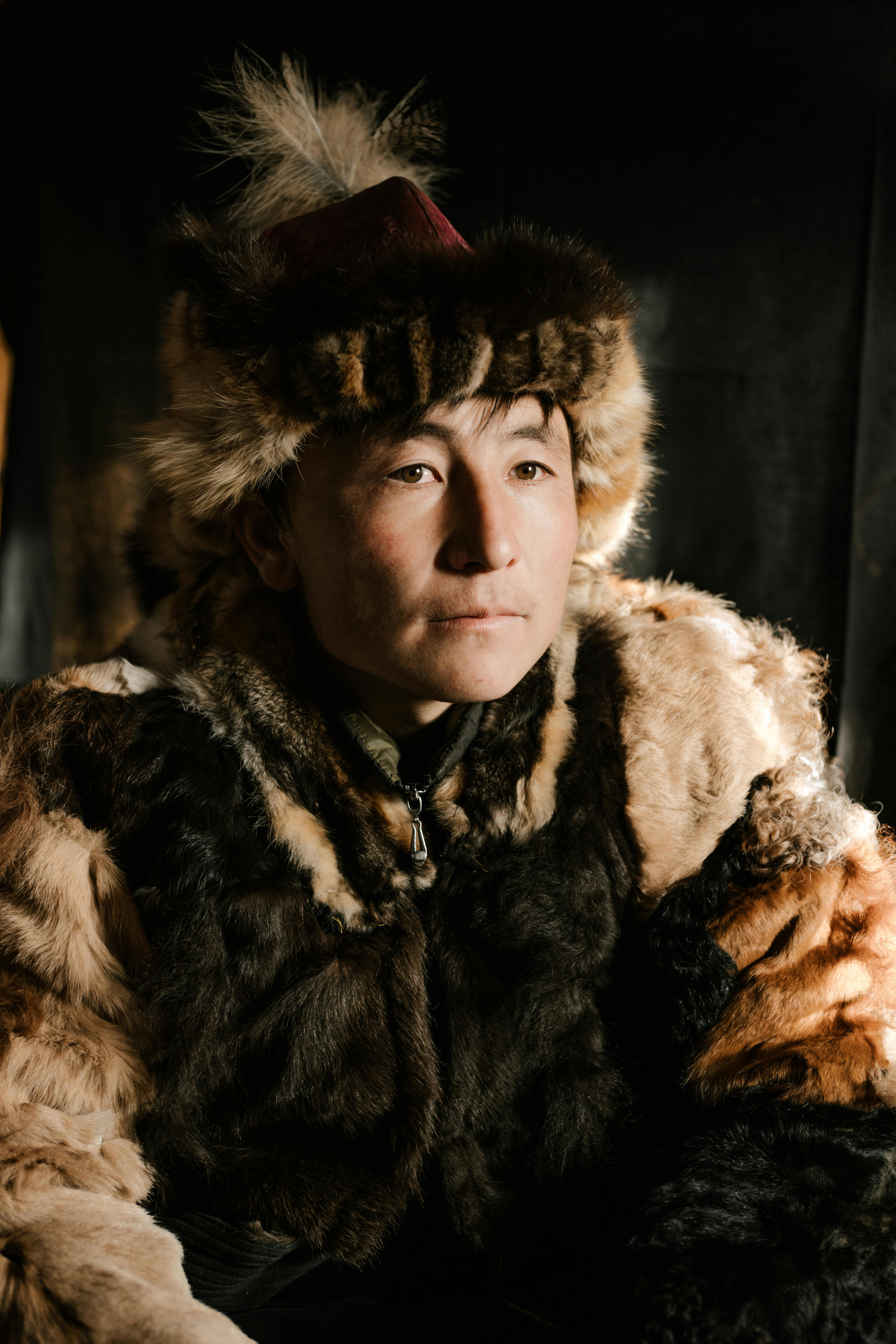 Close-up portrait of a man wearing a fur coat with traditional attire, highlighting cultural heritage.