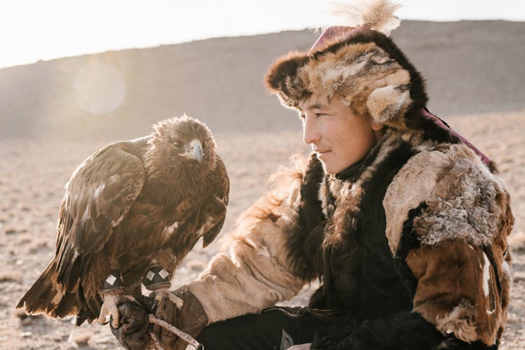 Man In Traditional Fur Clothes Holding An Eagle