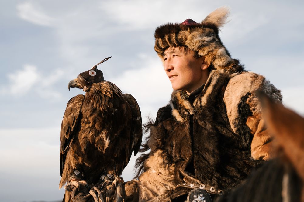 Cazador kazajo con sombrero de piel y águila dorada en el brazo