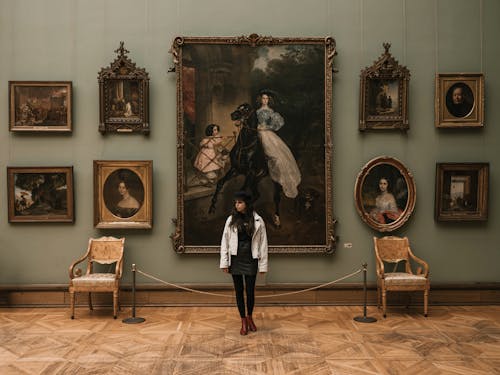 Woman Standing in front of Paintings in a Museum