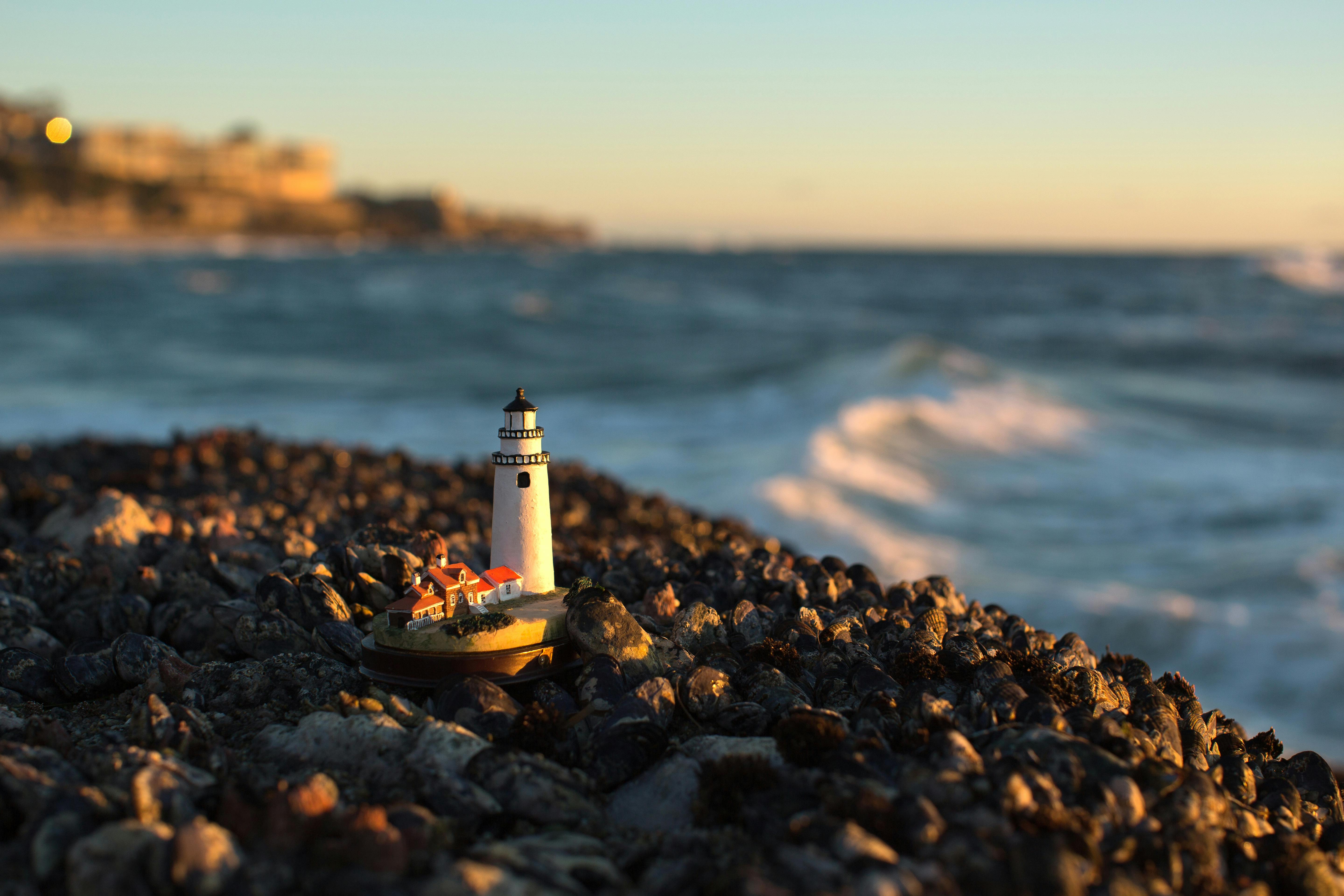 Close-up of Lighthouse Figurine on Rocks on the Beach