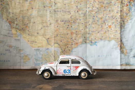 Close-up of a vintage toy car model with map background, symbolizing travel and exploration.
