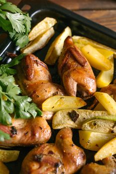 Delicious roasted chicken thighs with herb-seasoned potatoes on a baking tray.