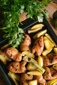 Savory roasted chicken and vegetables garnished with fresh parsley on a baking tray.