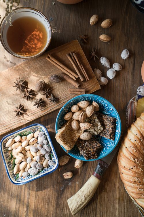 Free Top view of nuts, spices, and tea on a wooden kitchen counter, creating a warm rustic atmosphere. Stock Photo