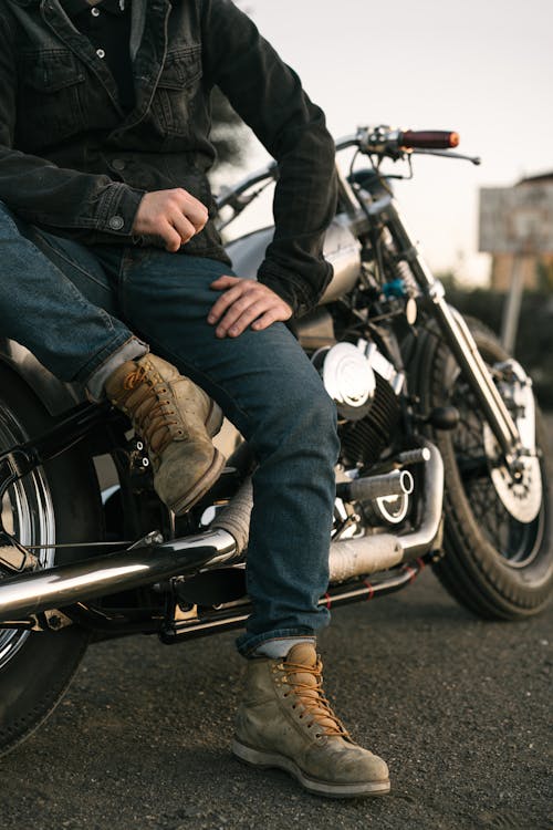 Person in Blue Denim Jeans Sitting on Black Motorcycle