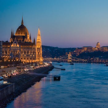 Stunning view of Budapest's Parliament and Chain Bridge illuminated at twilight over the Danube River.