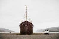 Brown Ship on Brown Sand Under White Sky