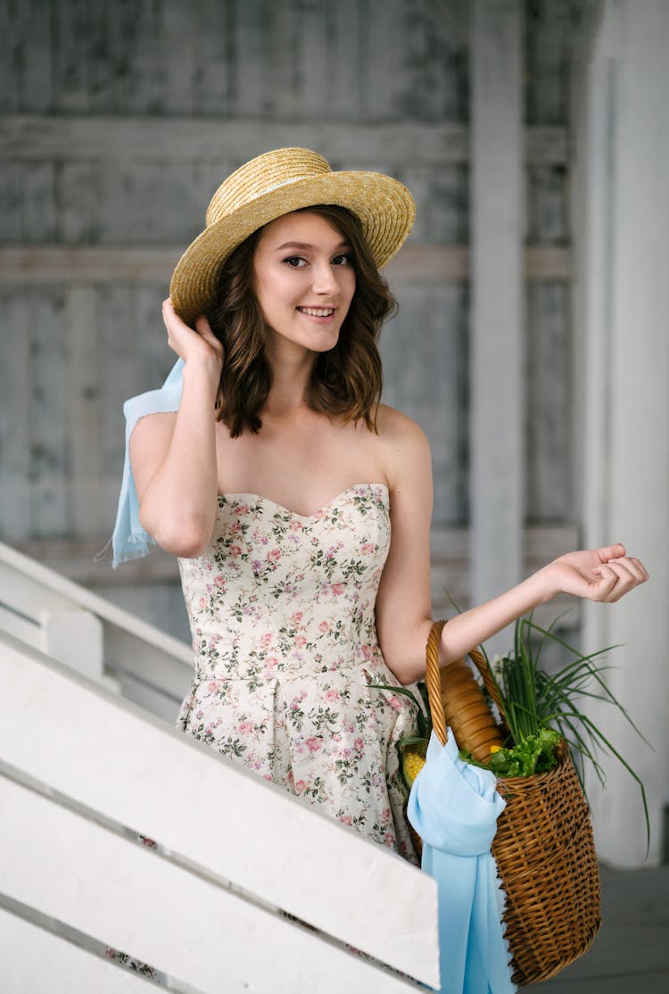 Smiling Woman In A Hat Carrying Bags And A Basket