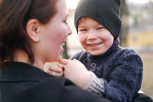 Free A joyful moment between a child and mother, captured with warm smiles outdoors. Stock Photo
