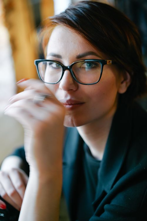 Free Captivating portrait of a woman with eyeglasses, set in a soft, introspective mood. Stock Photo
