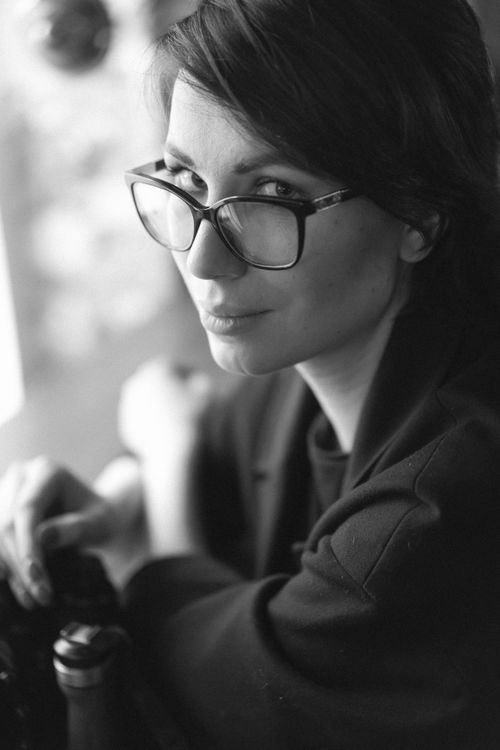 Free Elegant black and white portrait of a woman with eyeglasses and long hair indoors. Stock Photo