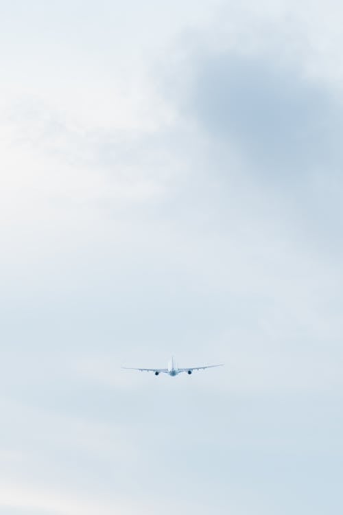 Free Plane Over a Cloudy Sky Stock Photo
