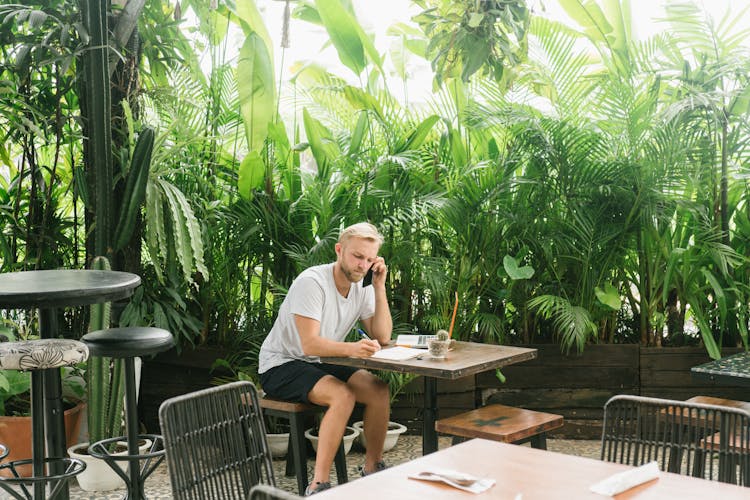 Man Sitting With A Phone At A Restaurant