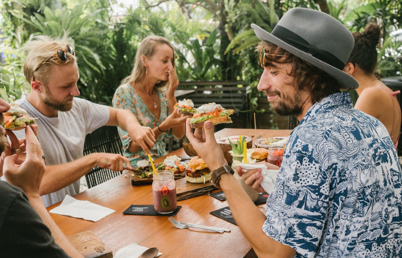 Group of friends enjoying a relaxed meal outdoors, sharing laughs and food.