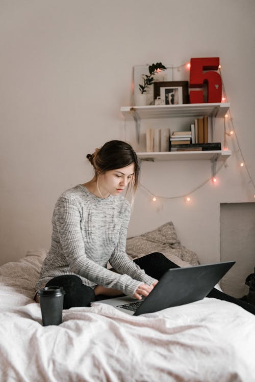 Woman in Gray Knit Sweater Using Black Laptop 