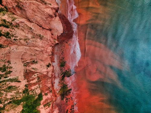 Free A breathtaking aerial shot of the red cliffs and sea along Devon's coastline in England. Stock Photo