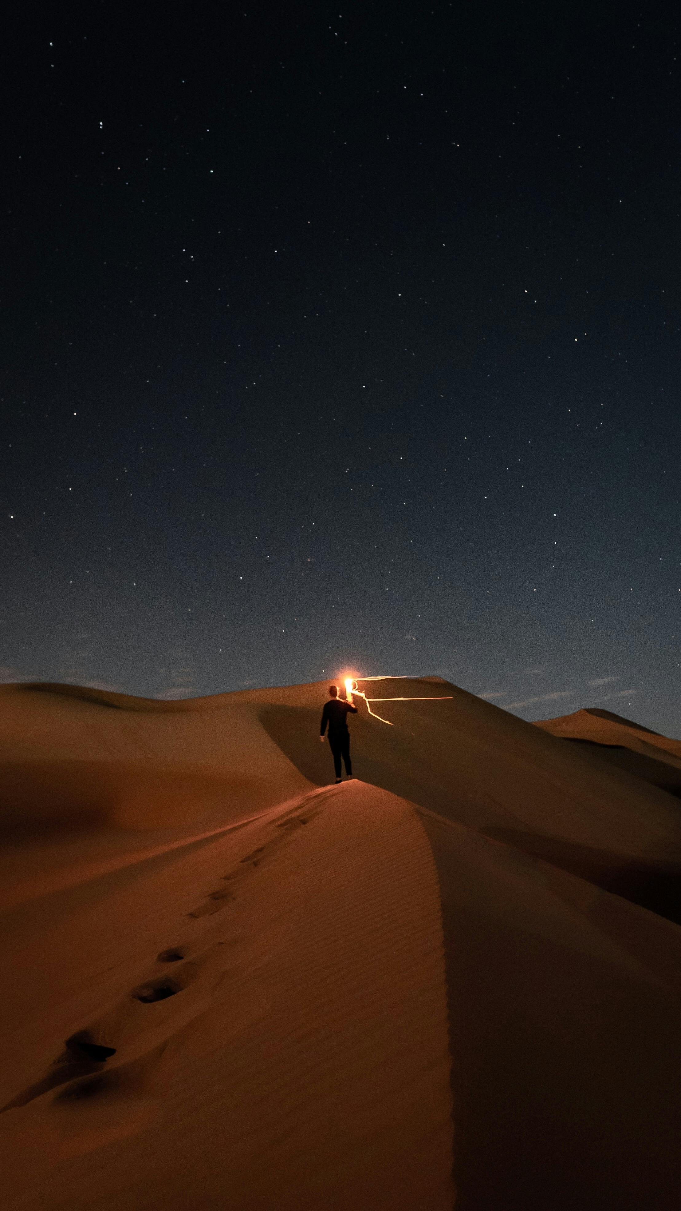 person standing in the desert during night time