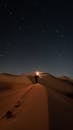 Person Standing in the Desert during Night Time