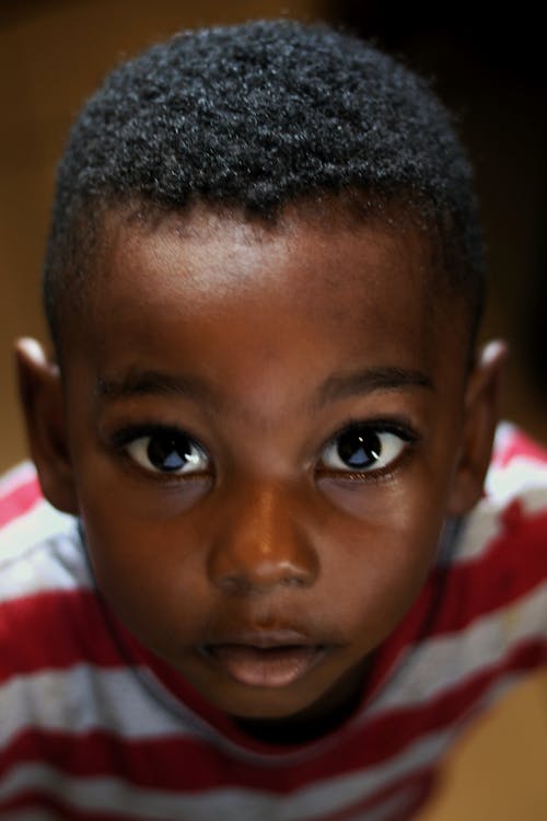 Charming black boy with deep gaze in striped wear