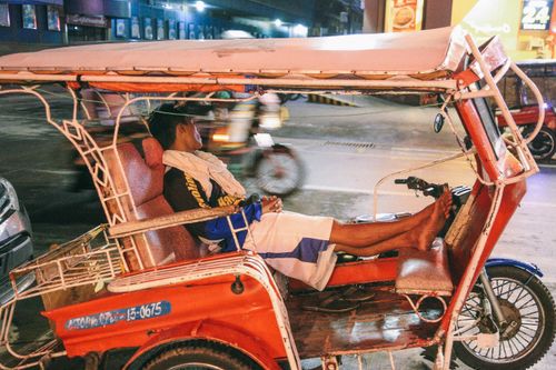Free A rickshaw driver resting at night in Dumaguete, capturing a candid street scene. Stock Photo
