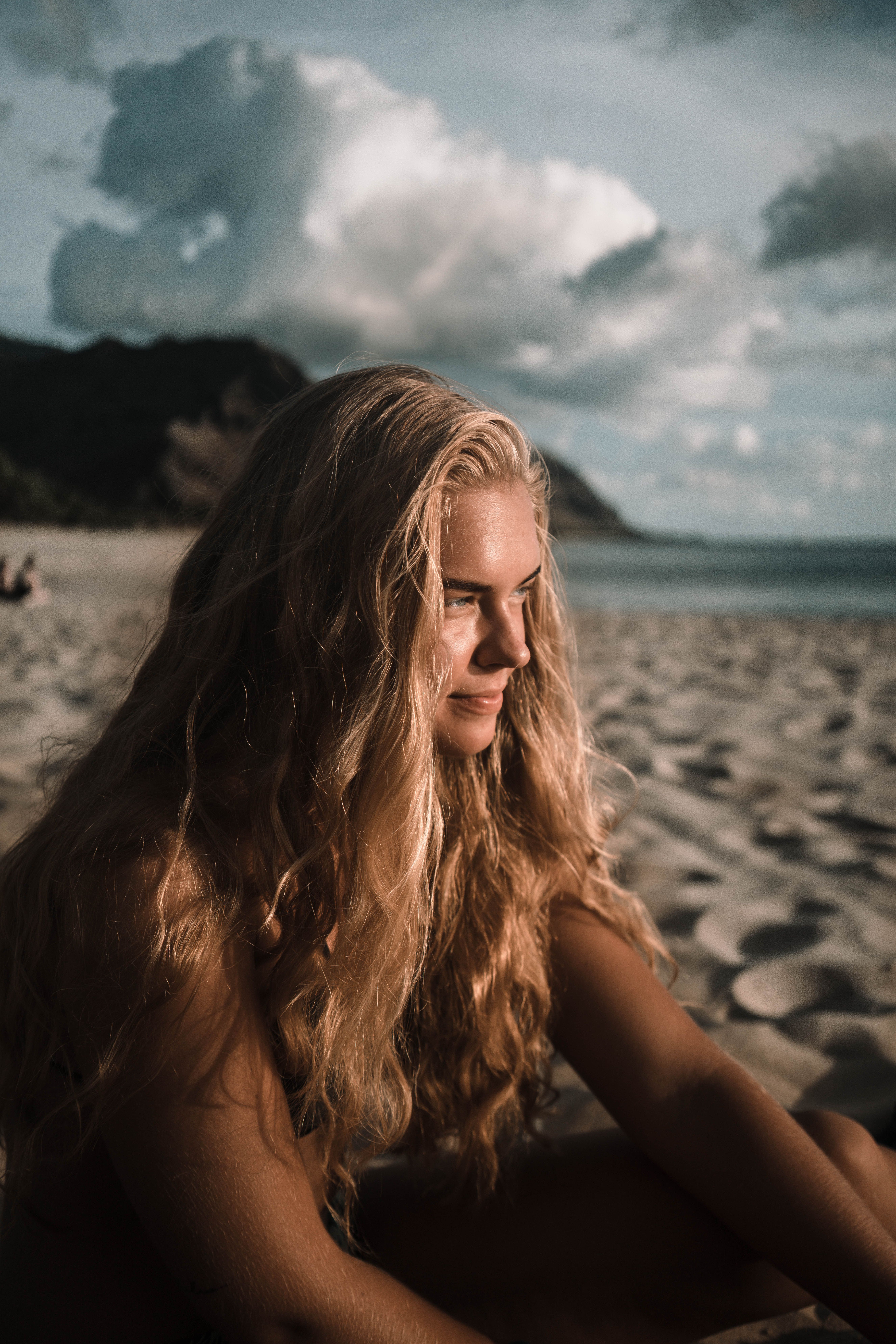 Young Blonde Woman Sitting on a Beach · Free Stock Photo