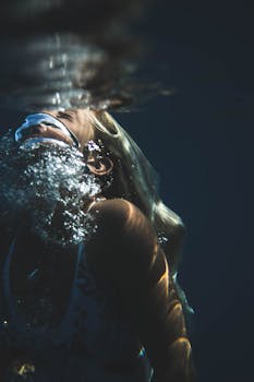 Dynamic underwater portrait capturing a woman exhaling bubbles.