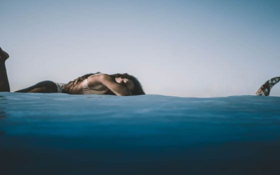 A woman enjoying a peaceful moment by the water, evoking summer vibes and tranquility.