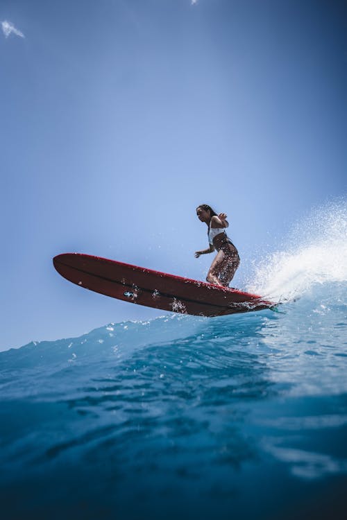 Free Woman in White Bikini Standing on Red Surfboard Stock Photo