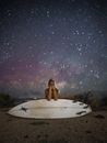 一位拿着冲浪板的女人站在令人惊叹的星空下