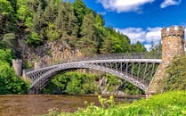 一座历史悠久的桥梁坐落在郁郁葱葱的绿树和岩石悬崖之间