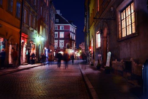 Person Walking on Road Between Buildings