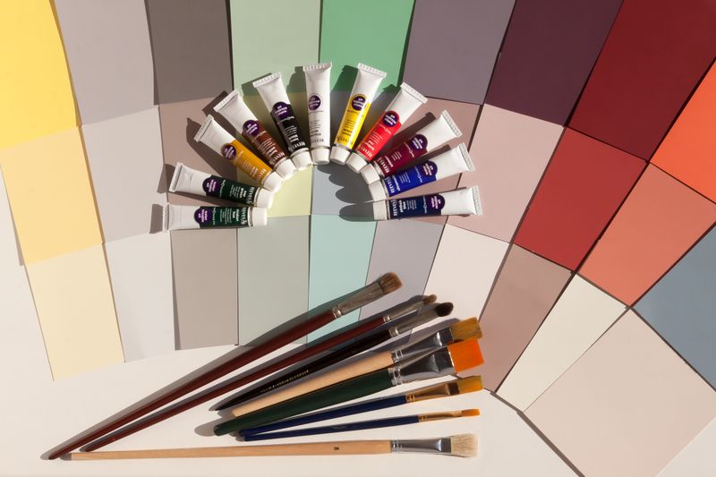 Assorted colorful acrylic paints and paint brushes ready for party