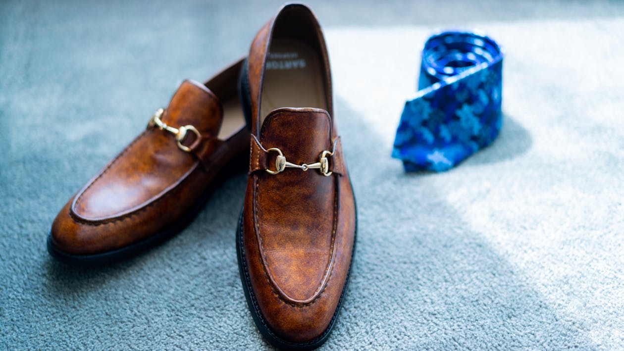 Free Classy brown shoes and tie placed on floor Stock Photo