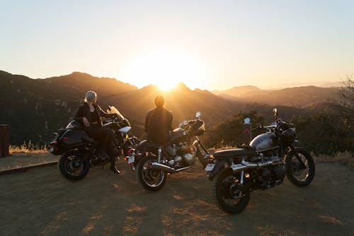 A Woman in Black Jacket Siting on Motorcycle during Sunset