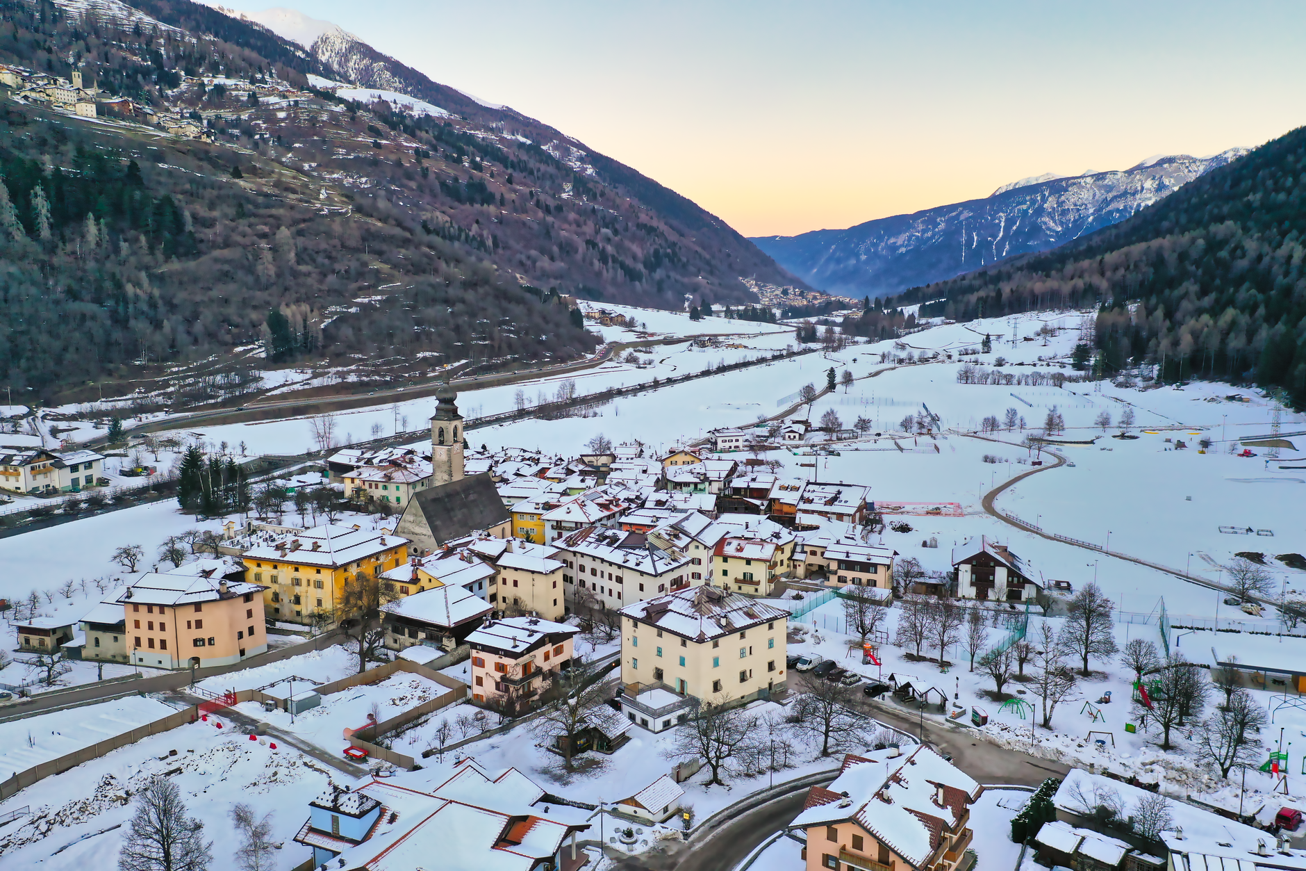 Aerial view of snow-covered Pellizzano in Trentino-Alto Adige, Italy, during winter twilight.