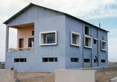 A modern two-story concrete building showcasing a distinctive architectural facade.