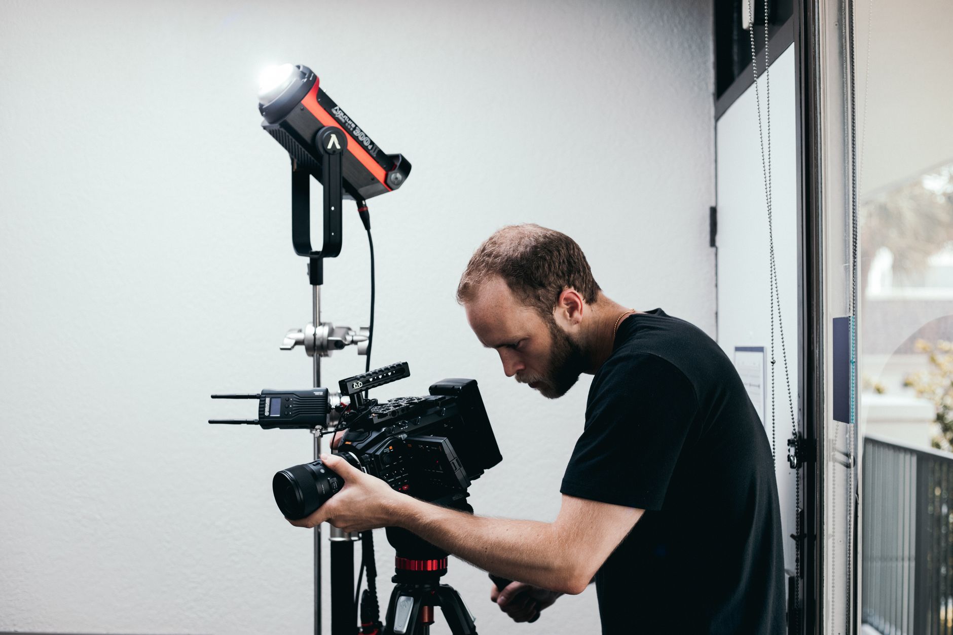 Cameraman setting up professional camera and lighting in a studio.