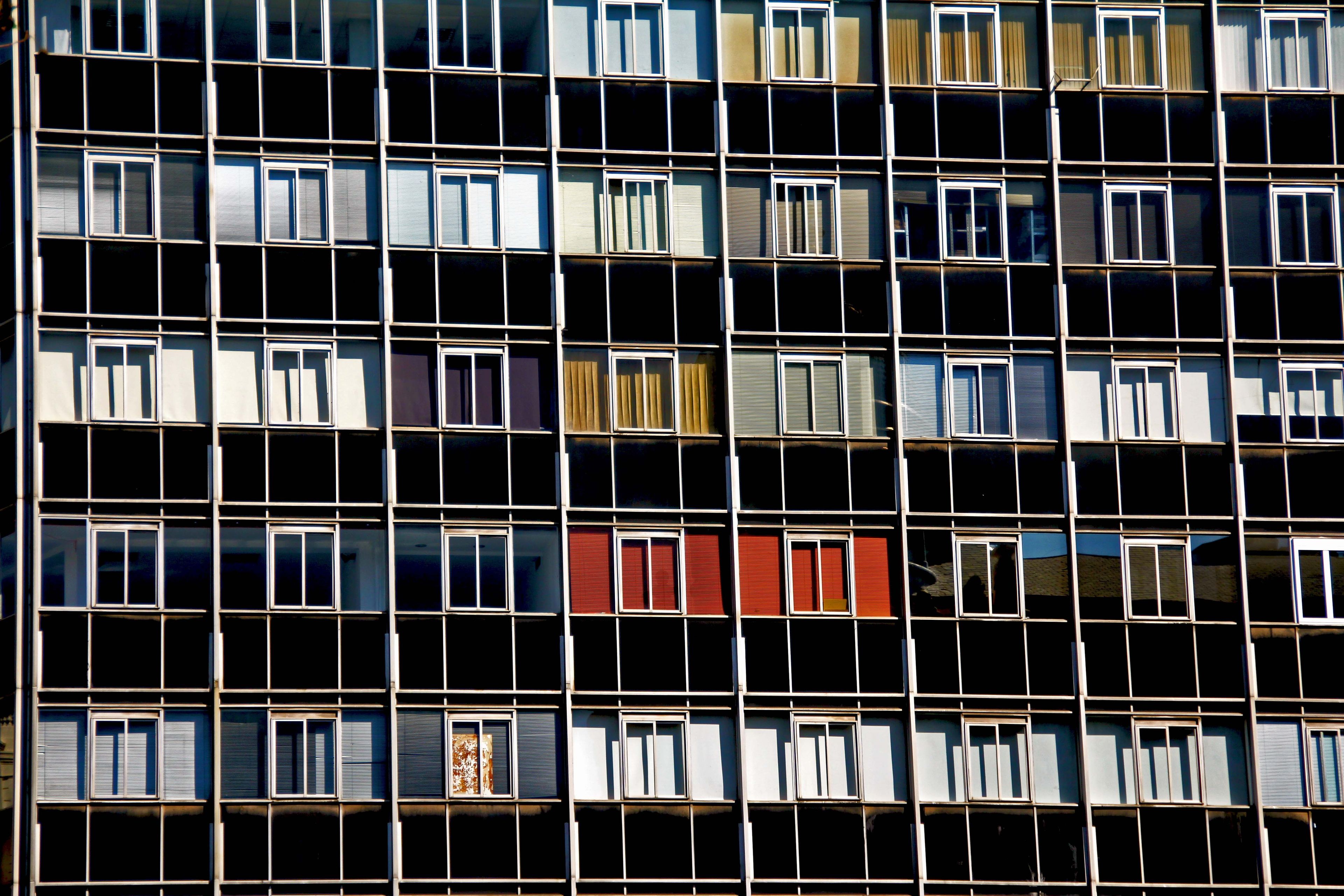 Façade en trame d'immeuble d'après-guerre Façade d'un immeuble d'après-guerre réduite à sa trame régulière de fenêtres, quelques panneaux colorés rompant la grille